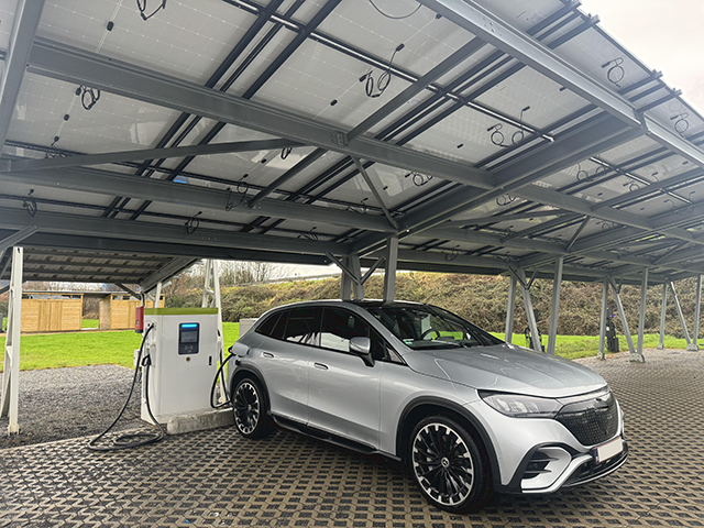 An electric vehicle charging under a carport using a PowerBoost DC charger