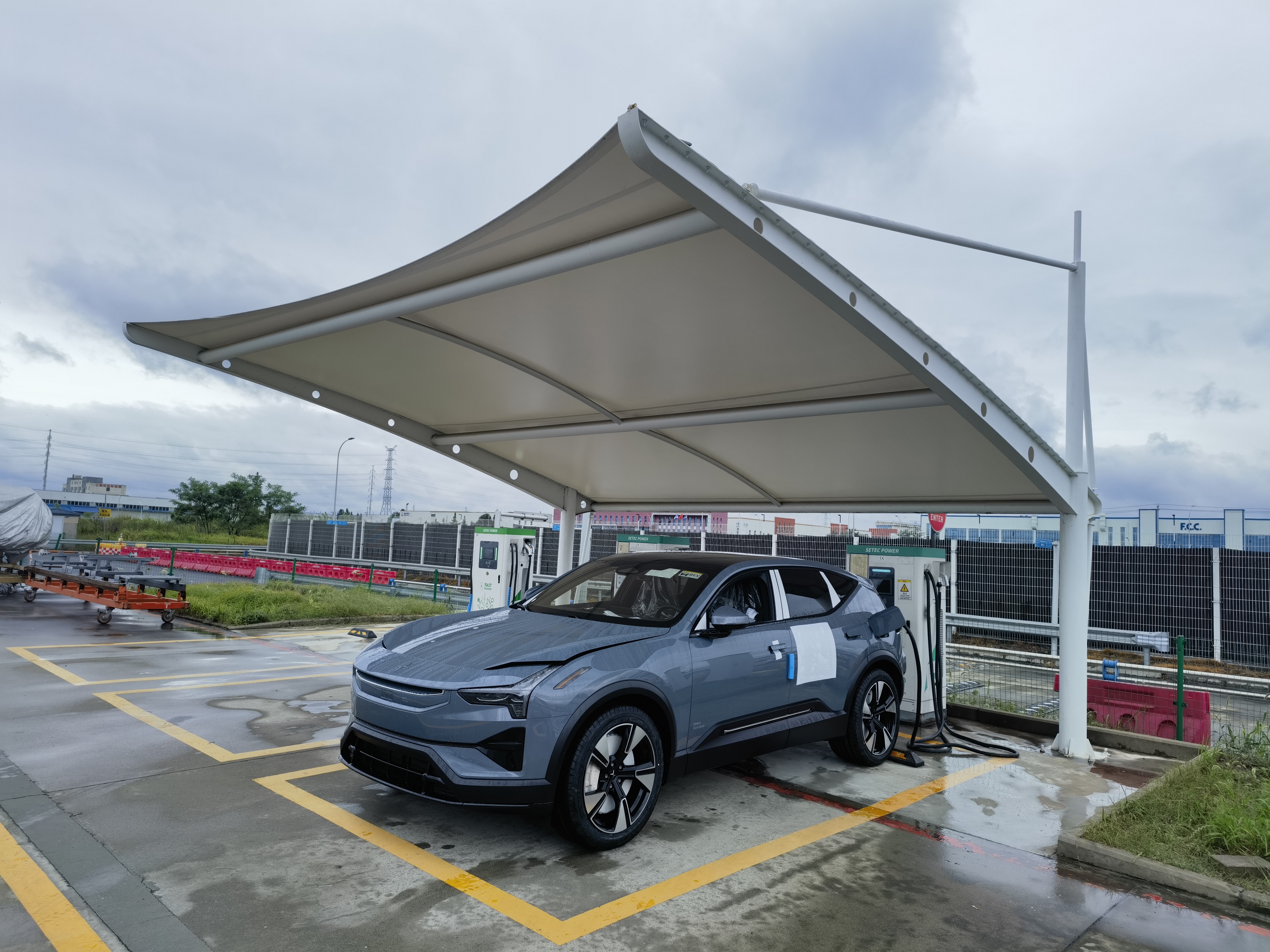 Electric SUV charging at a Setec Power DC fast charging station under a covered EV charging canopy.